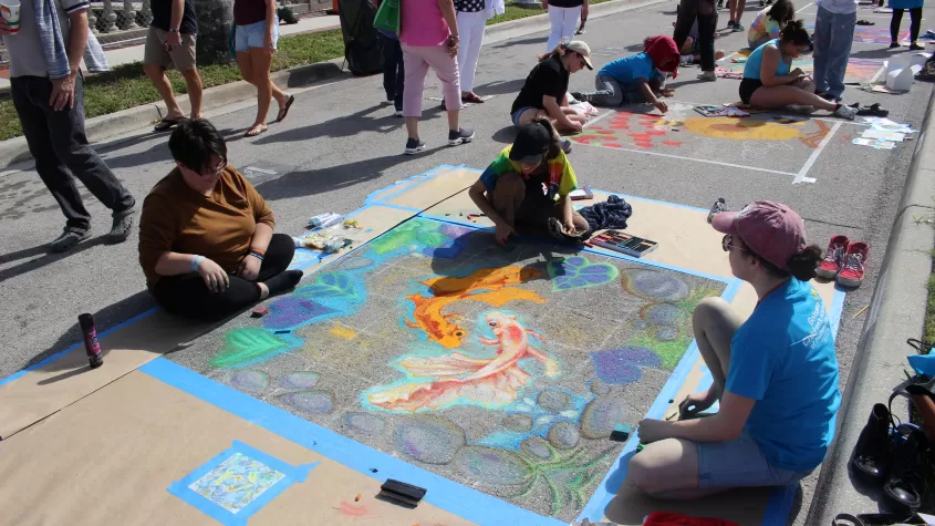 The first place winners of our high school street painting competition, "Chalk Block",  in the process of working on their winning piece as a team.