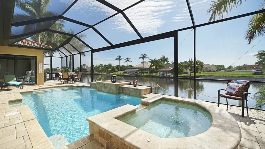 Villa Francesca - a large pool area with a connected spa overlooking a large canal - SWFL Vacation Rentals