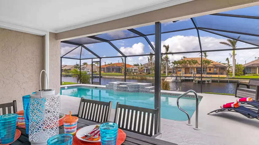 Villa Sunny - An outdoor dining area near the pool with sun loungers - SWFL Vacation Rentals