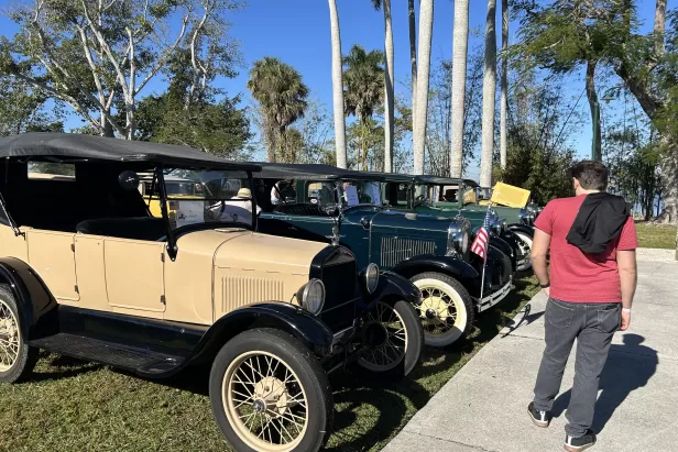 Visitors look at some of the Ford models of the decades at the car show. 
