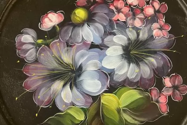 black background with flowers painted in muted blues, purples and pinks
