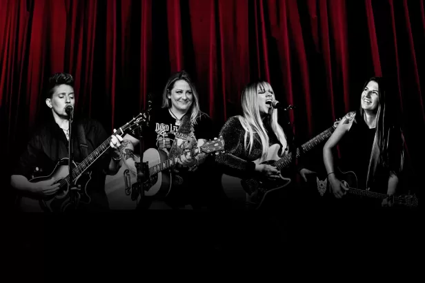 red curtains in background with four women in black and white shadows singing 
